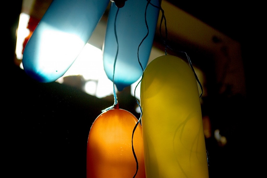 Blaue, gelbe und orange Luftballons im Gegenlicht